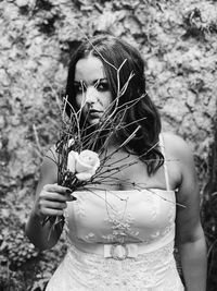 Portrait of bride holding twigs and rose