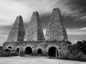 Low angle view of old building against cloudy sky