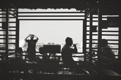 Rear view of silhouette people sitting at restaurant