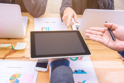 Midsection of man using laptop on table