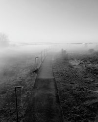 Boardwalk against sky during foggy weather