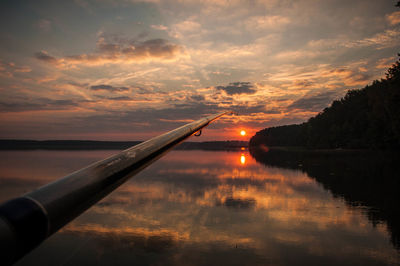 Close-up of fishing rod at sunset