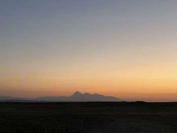 Scenic view of silhouette field against sky during sunset