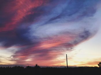 Scenic view of dramatic sky over silhouette landscape