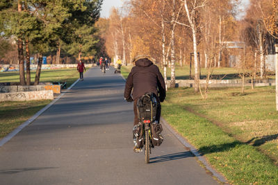 Rear view of man riding bicycle on road