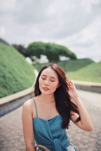 Young woman with long hair on footpath