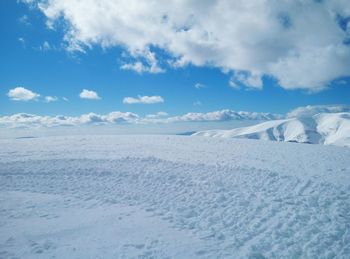 Scenic view of frozen landscape against blue sky