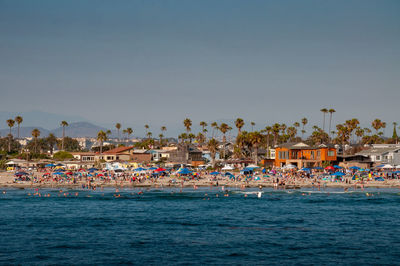 Group of people on beach against clear sky