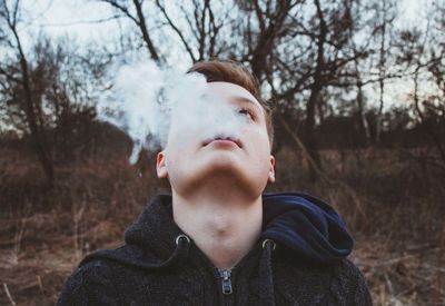 Handsome teenage boy with smokes looking up