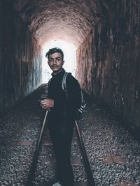 Portrait of young man standing on railroad track