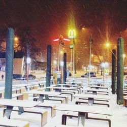 Illuminated tables and chairs at night during winter