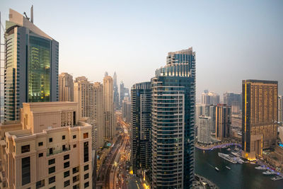 Aerial view of buildings in city against clear sky