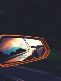 Reflection of man on side-view mirror of car