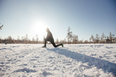 Winter outdoor sports for health promotion . a side view of a cute young athlete, in a snowy forest