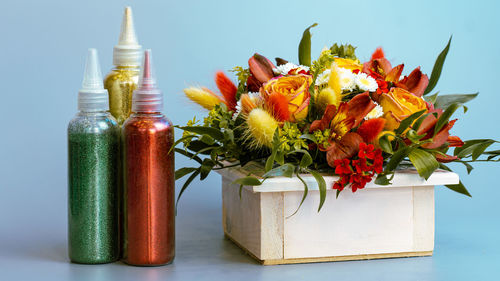 Close-up of red flower vase on table against white background