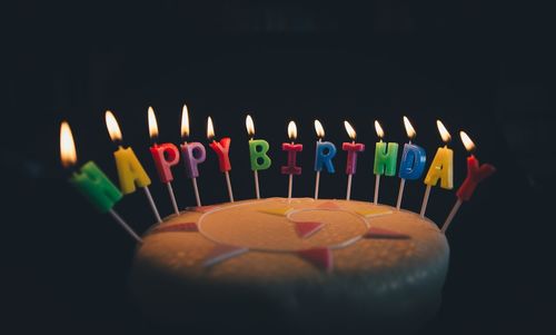 Close-up of illuminated candles against black background