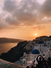 High angle view of townscape by sea against sky during sunset