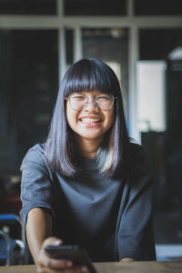 Portrait of smiling young woman using smart phone