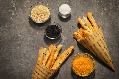 Salted cheese straws and sesame seeds in a paper cone