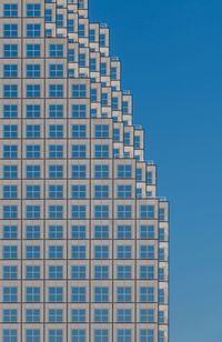 Low angle view of modern building against clear blue sky