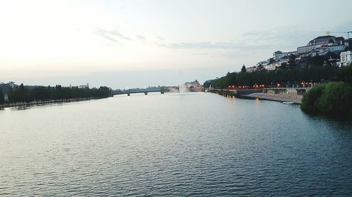 Bridge over river in city against sky