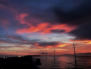 Scenic view of sea against dramatic sky during sunset