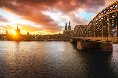 Bridge over river against sky during sunset