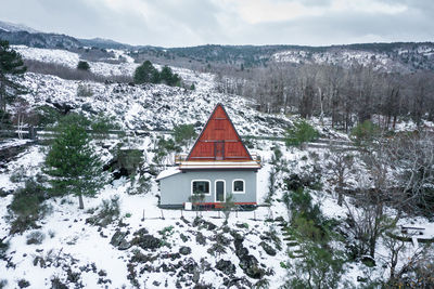 House on snow covered field by building