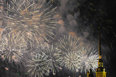 Low angle view of firework display over church at night