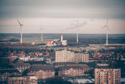 Smoke emitting from factory against sky