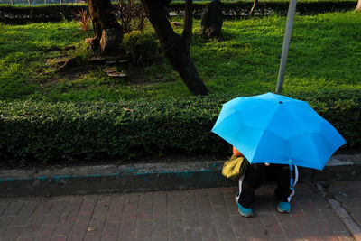 Low section of man walking on umbrella