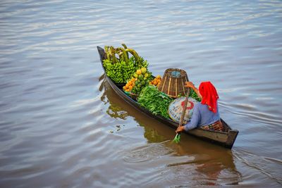 Woman sitting on fishing boat in lake