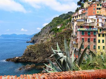 Scenic view of sea by buildings against sky