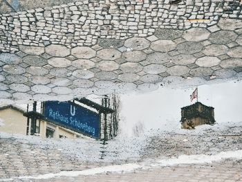 Buildings reflecting in puddle on street