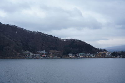 Scenic view of sea by buildings against sky