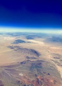 Aerial view of clouds over landscape against blue sky