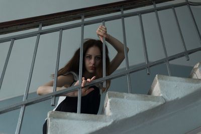 Woman looking at railing against sky