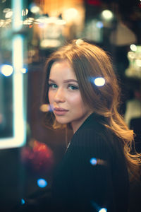 Portrait of woman with illuminated lights at night
