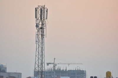 Cranes at construction site against clear sky