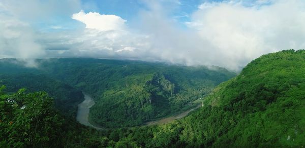 Panoramic view of green landscape against sky