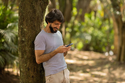 Young man at park on a beautiful sunny day with mobile phone.  working  leisure. green and nature 