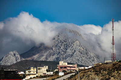 Aerial view of snowcapped mountain against cloudy sky