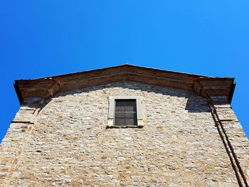 Low angle view of old building against clear blue sky