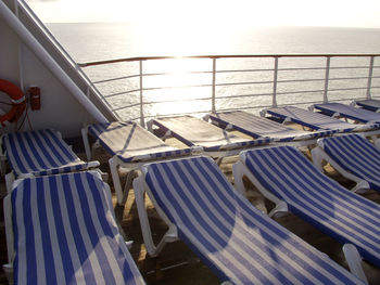 Lounge chairs on boat deck in sea