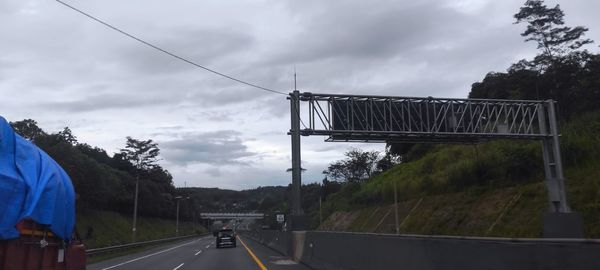 Road by bridge against sky