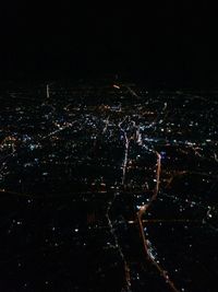 Aerial view of illuminated cityscape against sky at night