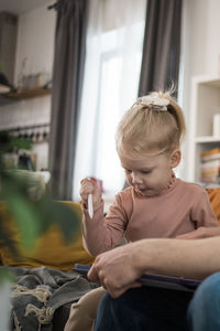 Young woman using mobile phone while sitting at home