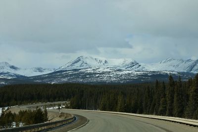 Road amidst snowcapped mountains against sky