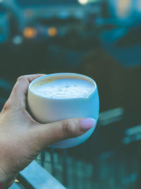 Close-up of hand holding drink against blurred background