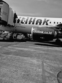 View of airplane at airport runway against sky